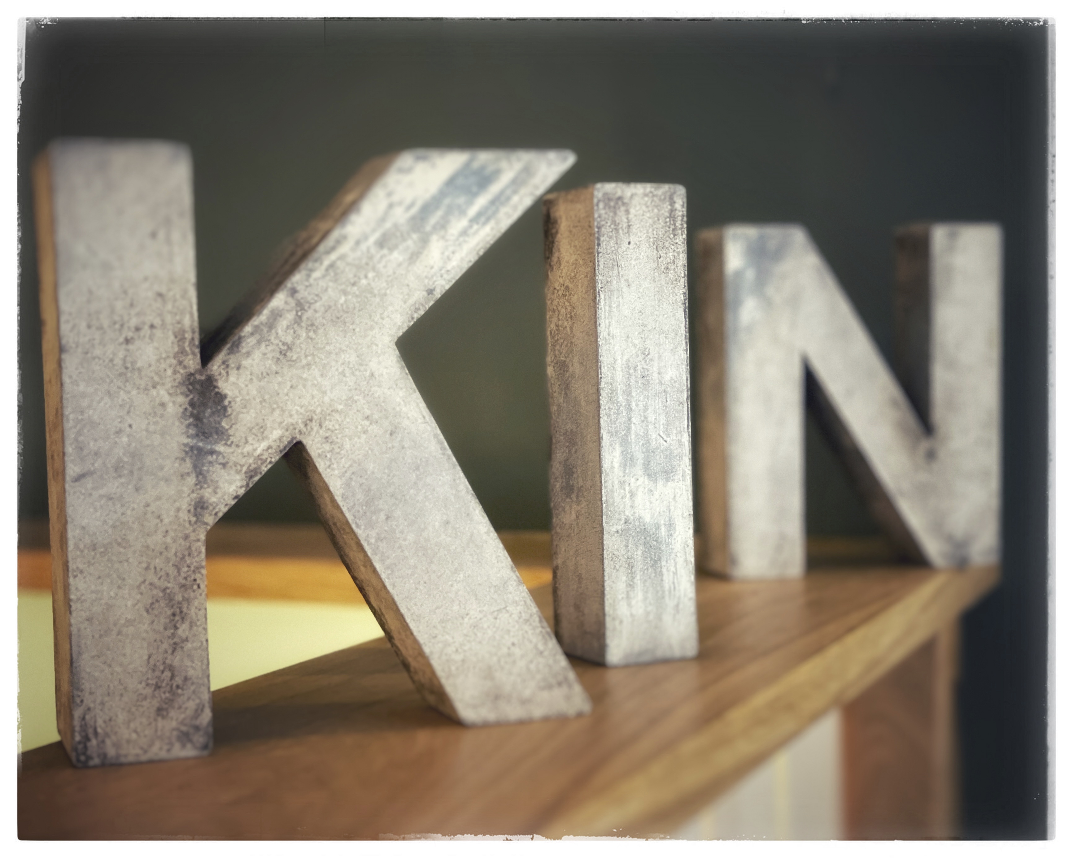 The letters, 'K', 'I', 'N' in wood on the cafe counter